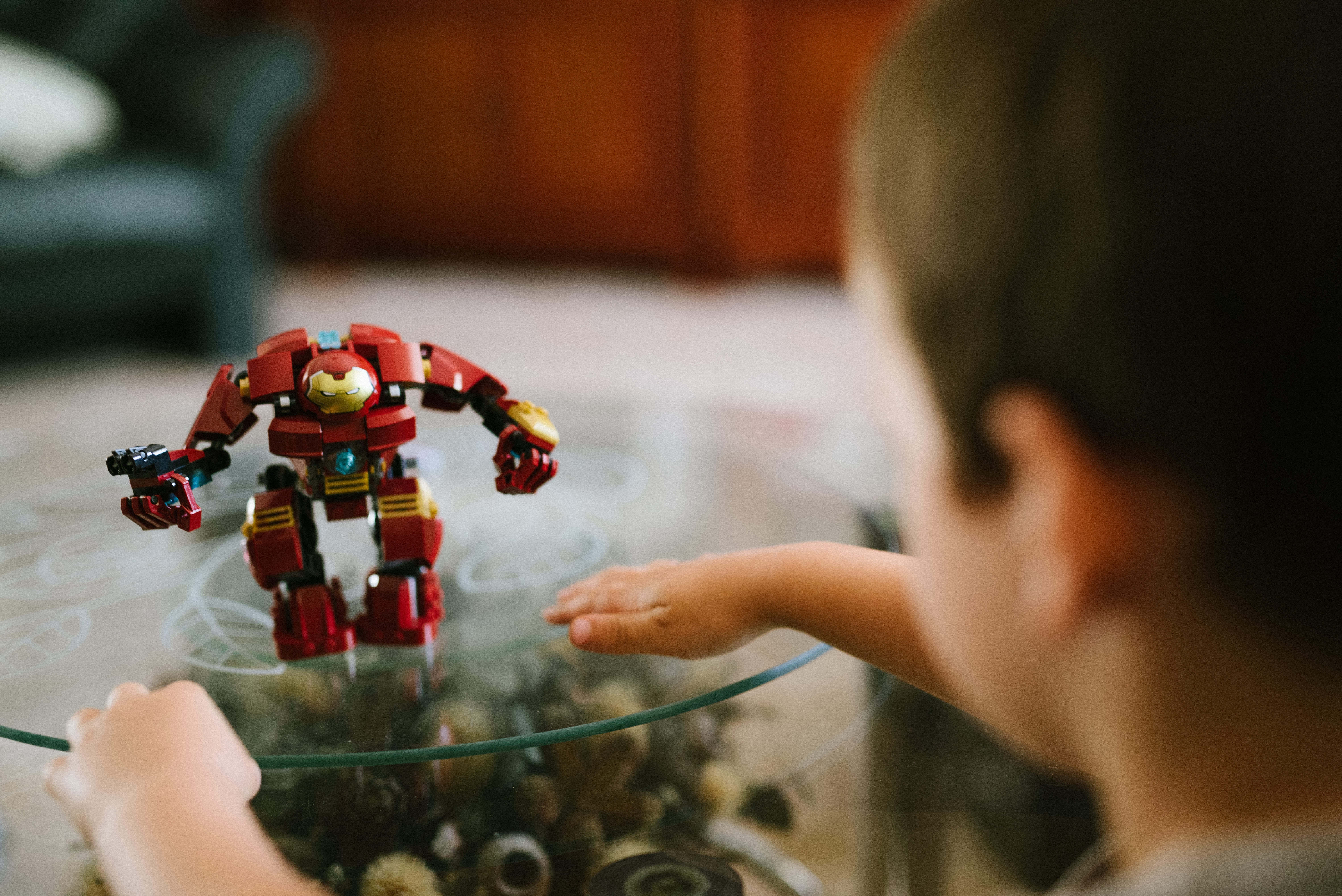 boy facing red and yellow ironman toy