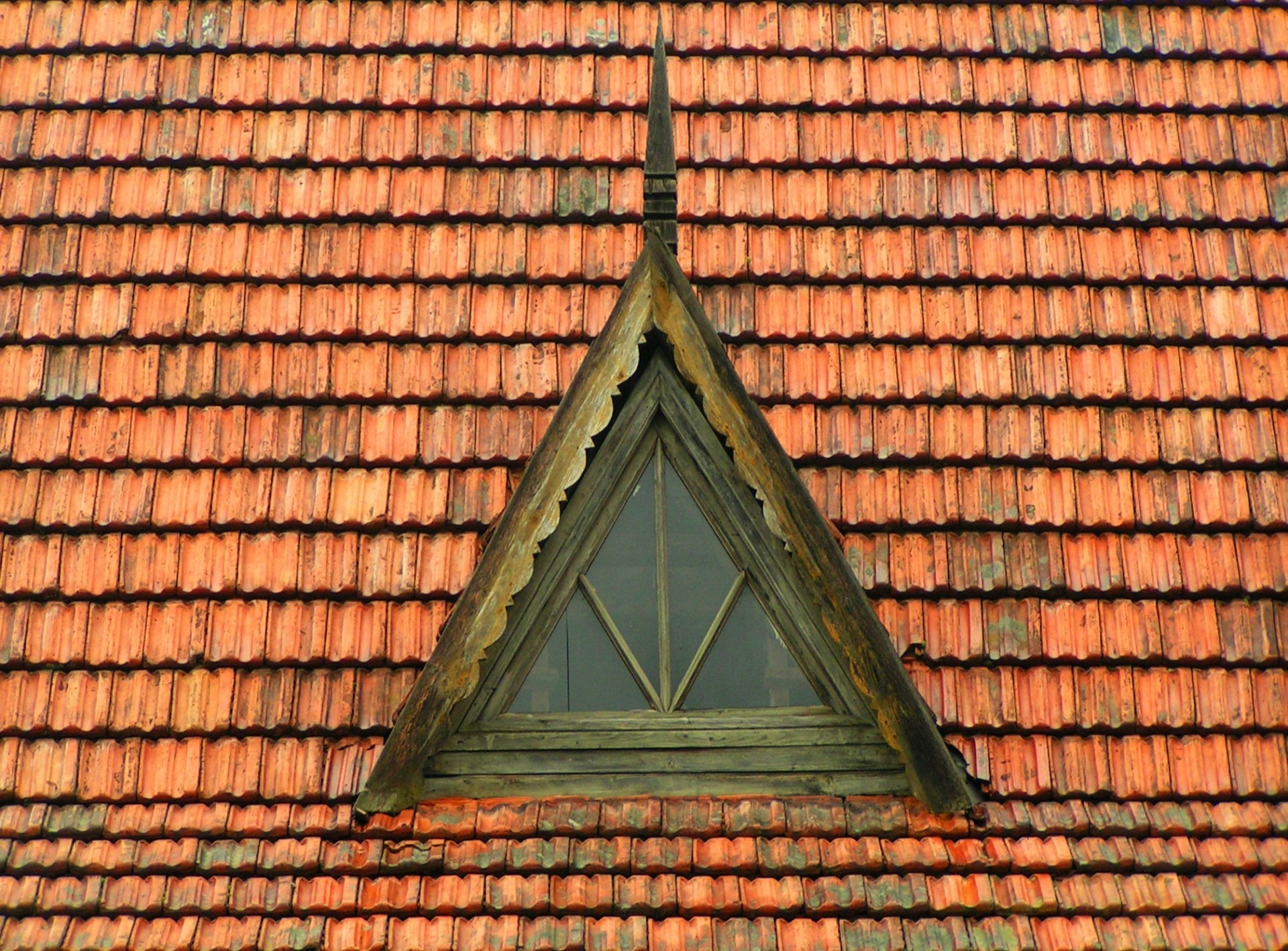 brown wooden framed clear glass triangular attic window