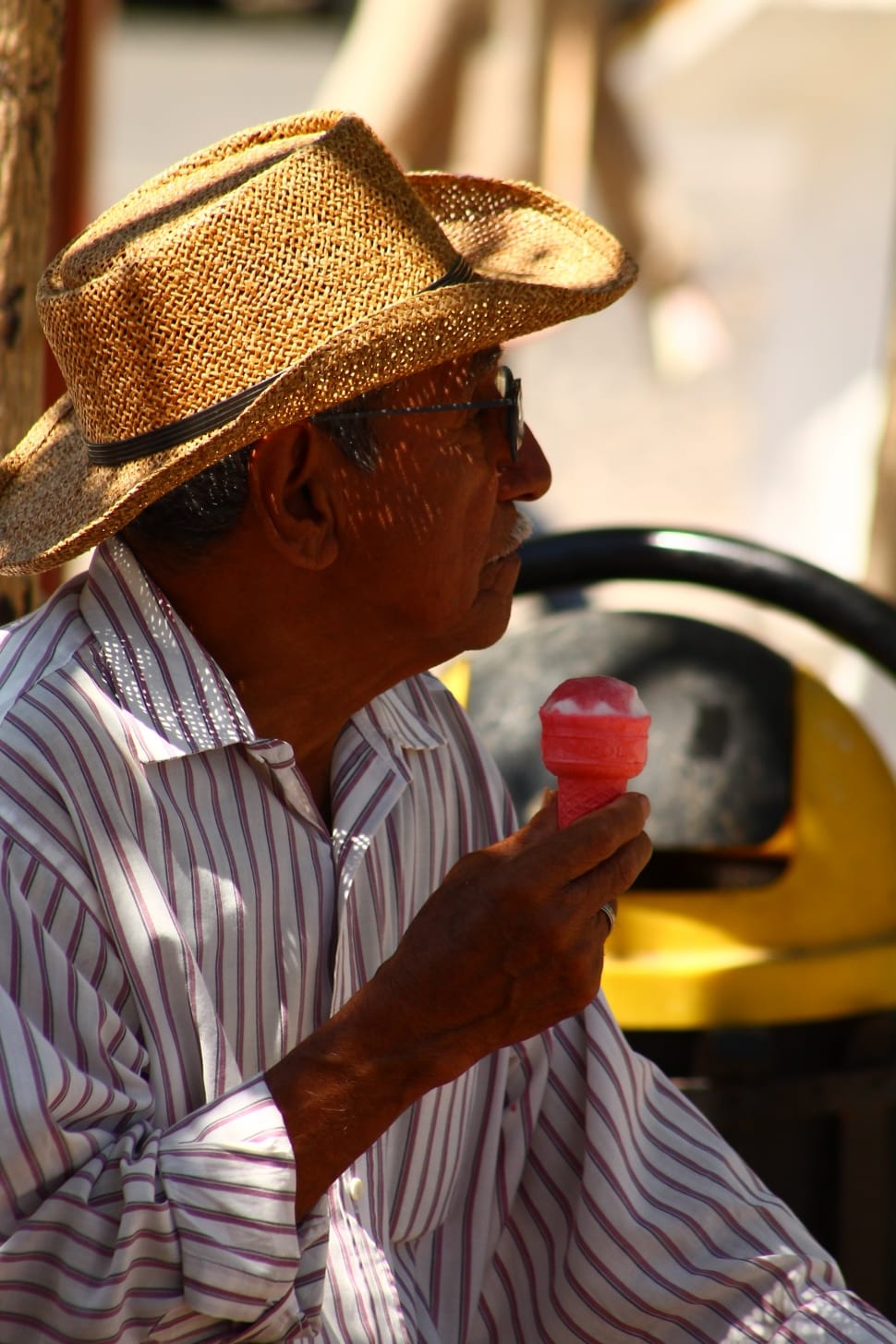 man in brown and white striped dress shirt wearing fedora hat holding ice cream preview