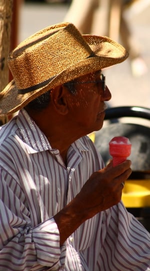 man in brown and white striped dress shirt wearing fedora hat holding ice cream thumbnail