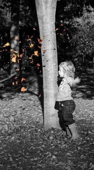 girl in black denim jeans playing with leaves thumbnail