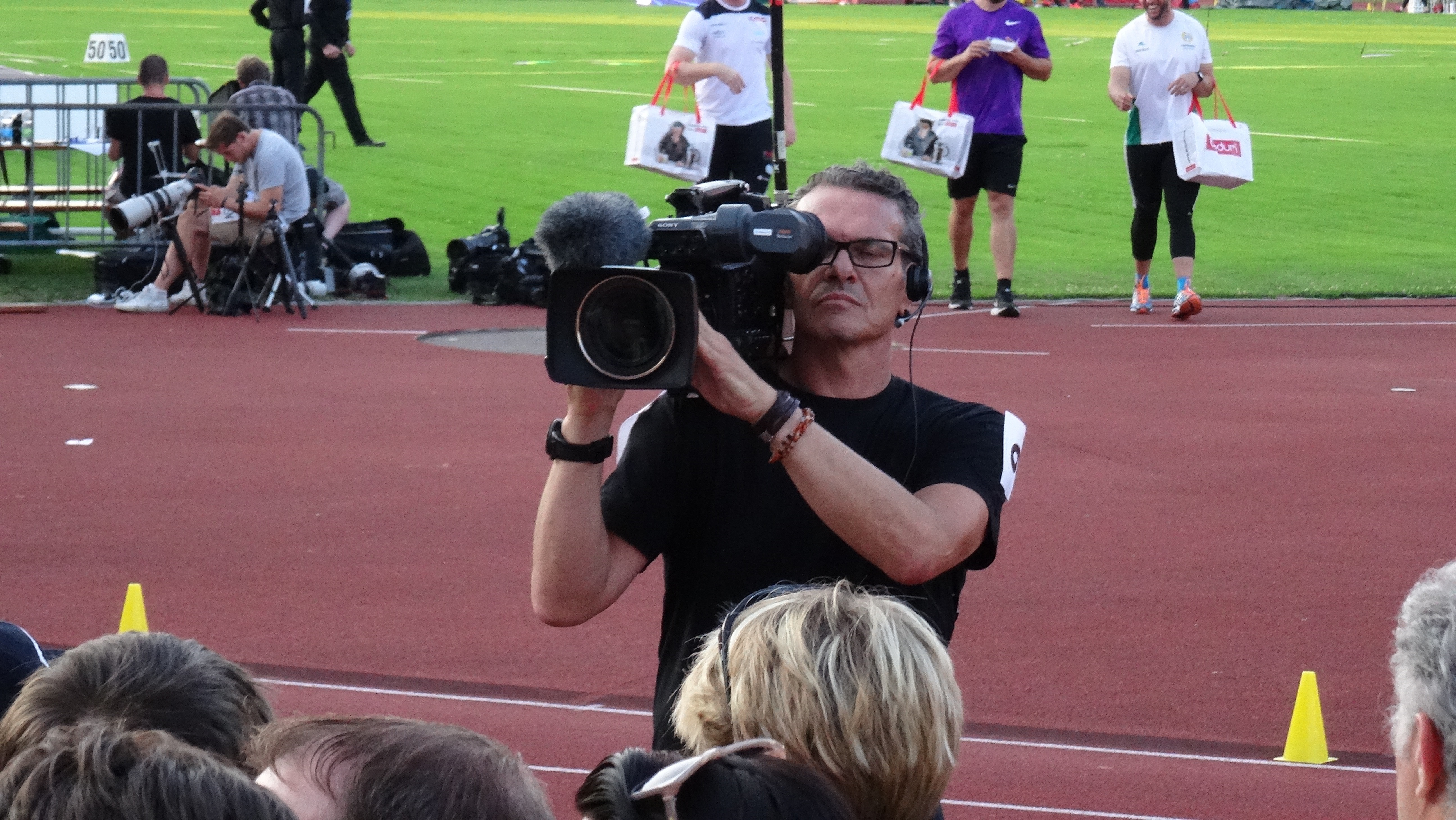 man in black crew neck shirt holding video camera