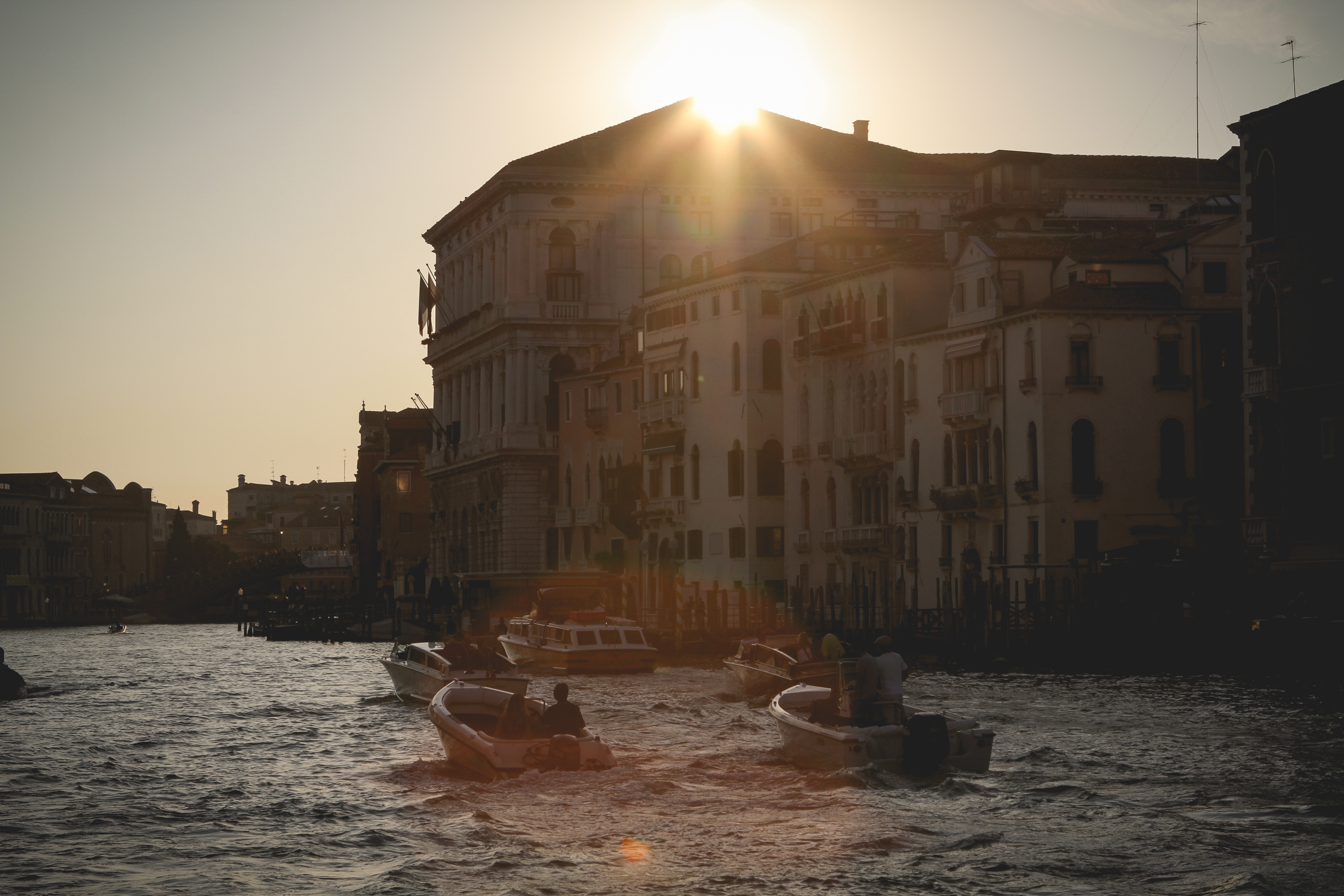 group of person riding on speed boats near city during sunse