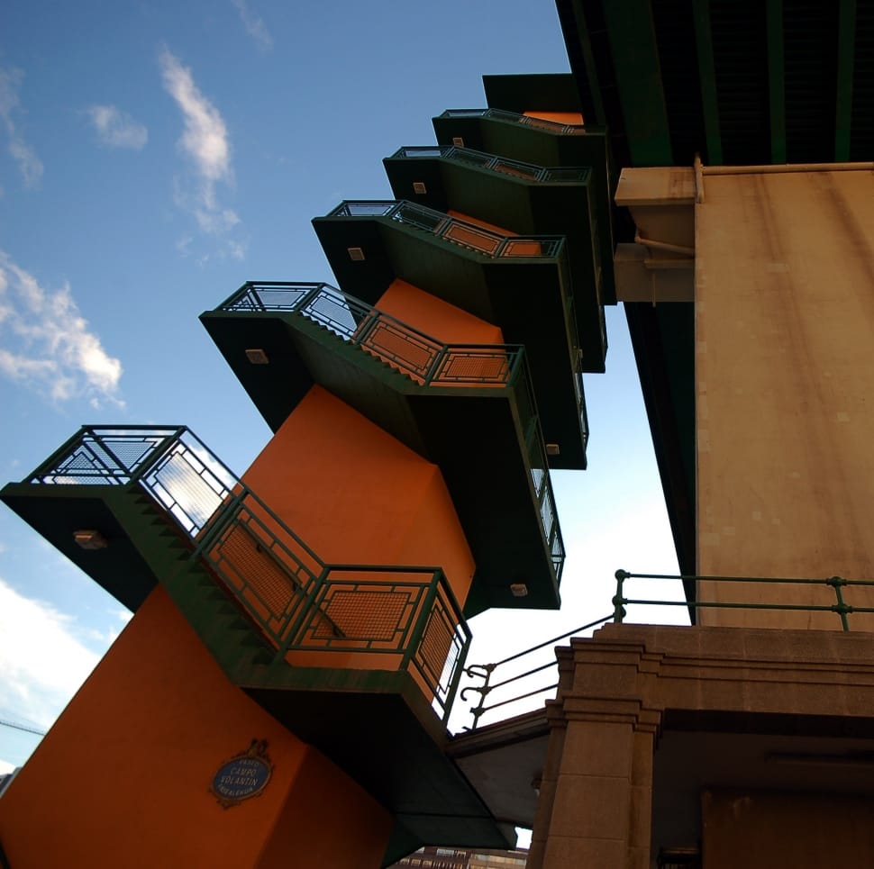 orange and green mid rise building with 5 tier stairway during daytime preview