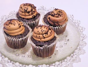four cupcakes on clear glass plate thumbnail