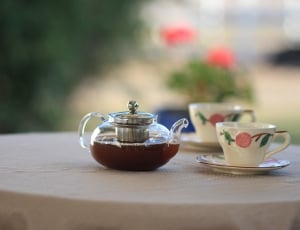 two ceramic white and pink teacups; clear glass coffee kettle thumbnail