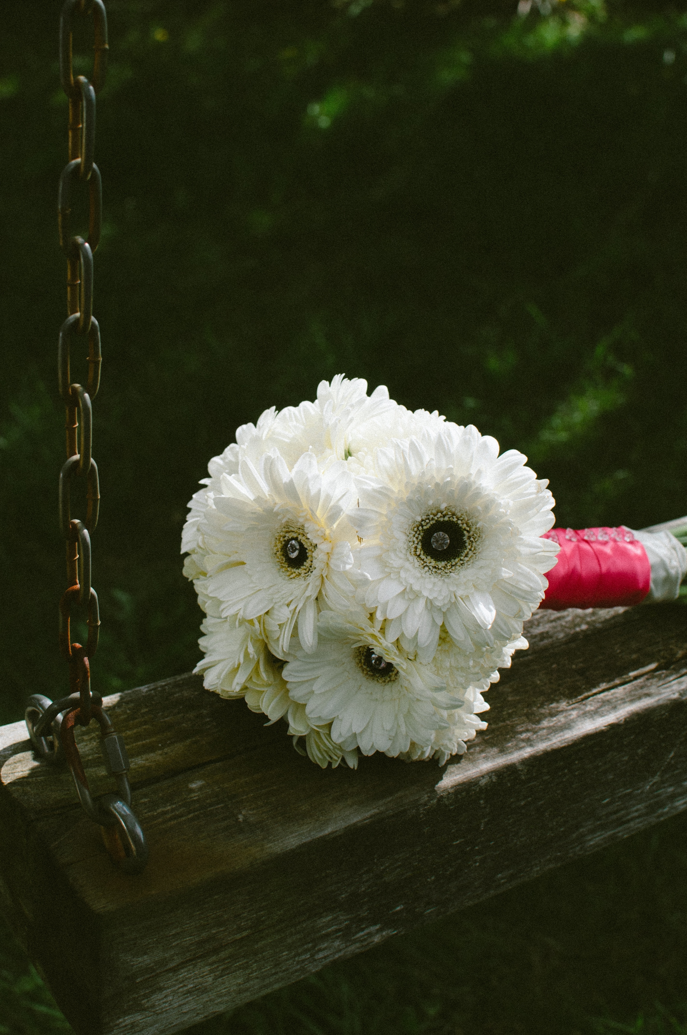 white petaled flower bouquet on brown wooden swing