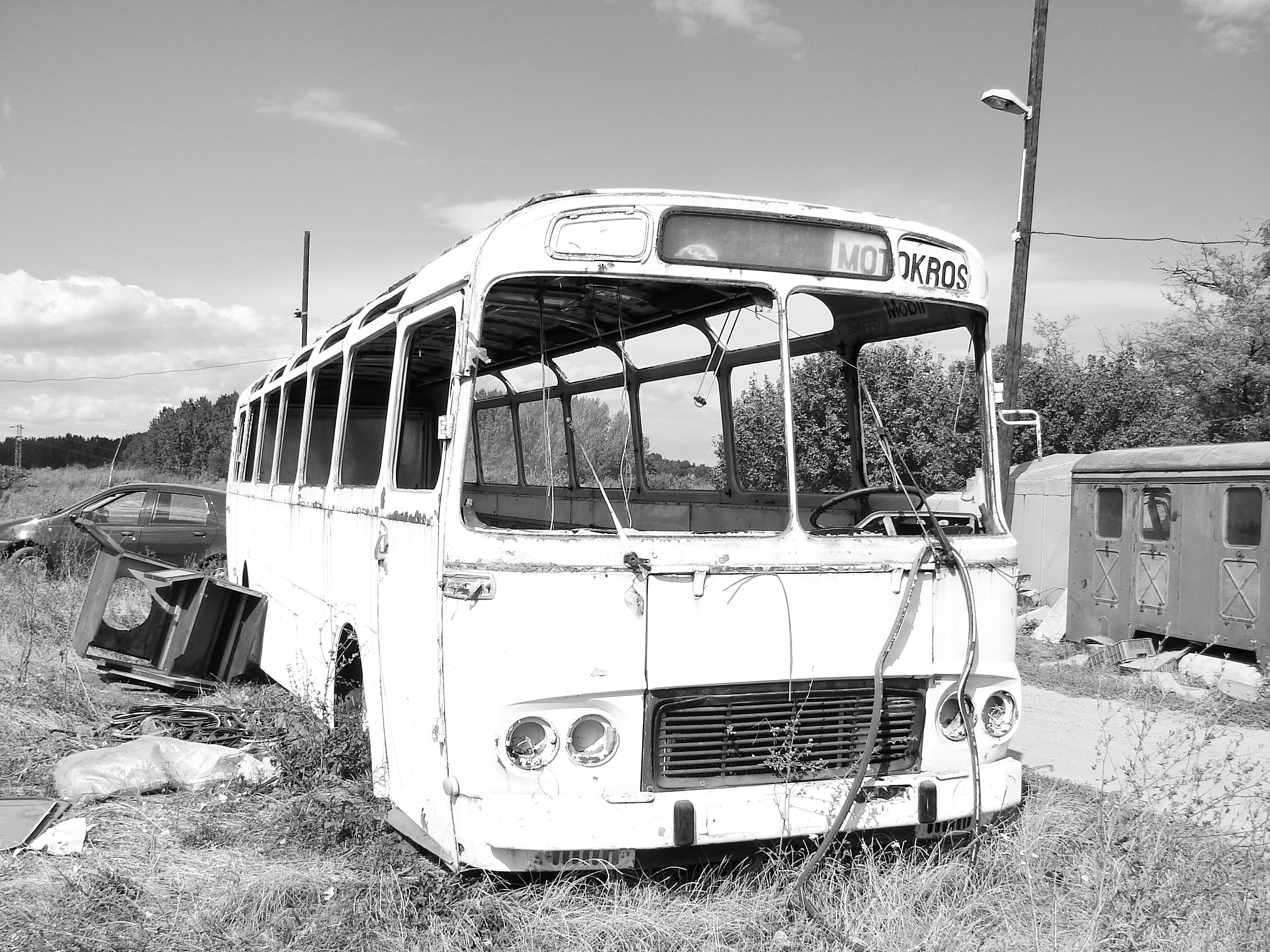 gray scale of white abandoned bus