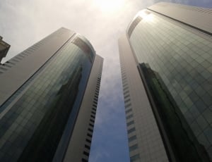 photo of two glass high rise building under cloudy sky thumbnail