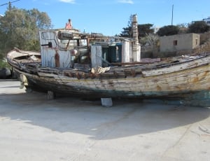 white and blue wooden boat on concrete surface thumbnail