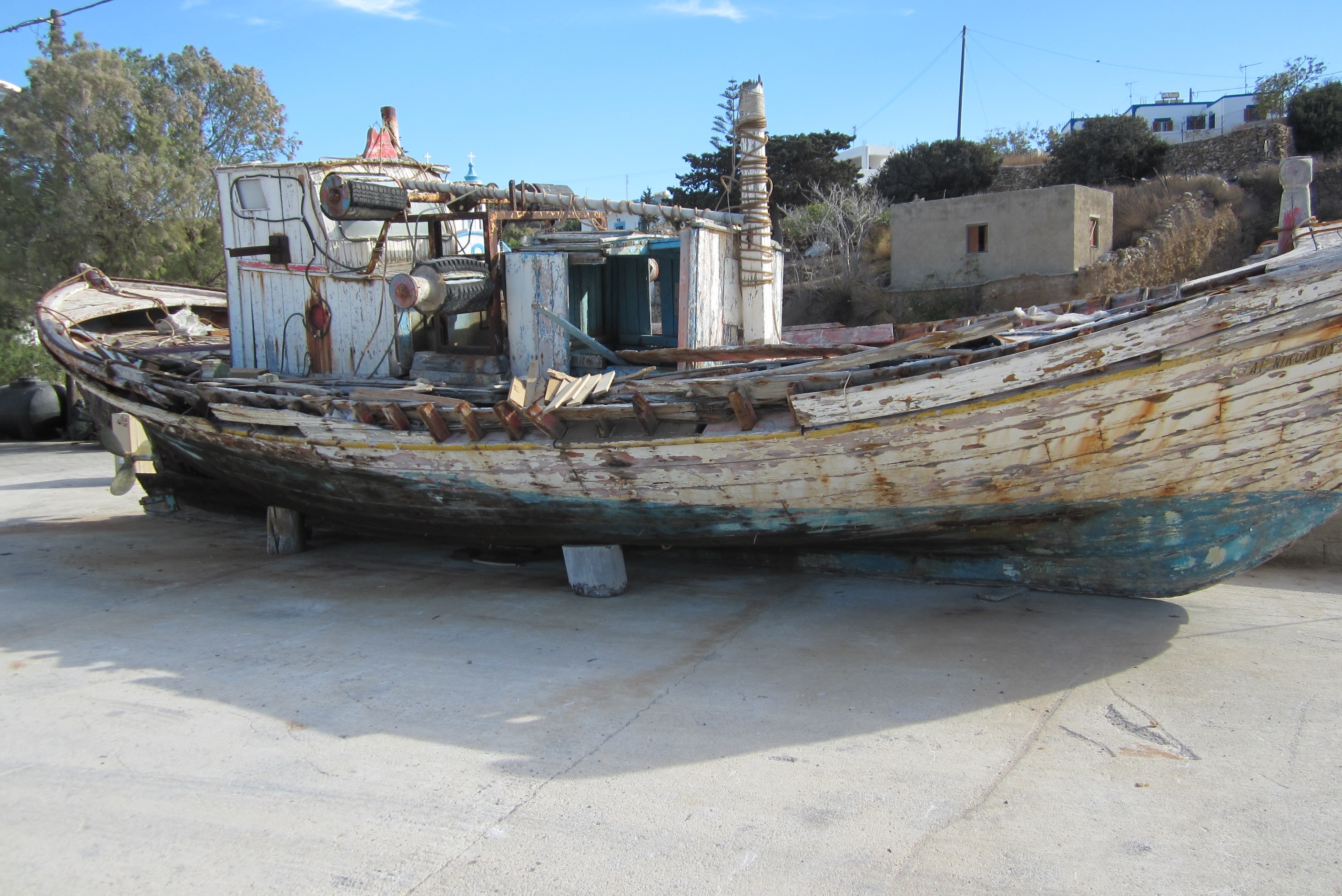 white and blue wooden boat on concrete surface