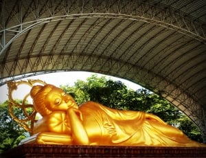 gold woman lying in pillow statue thumbnail