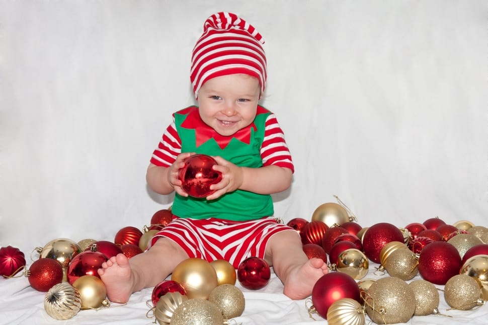 baby holding red bauble preview