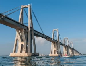 gray concrete bridge on body of water during daytime thumbnail