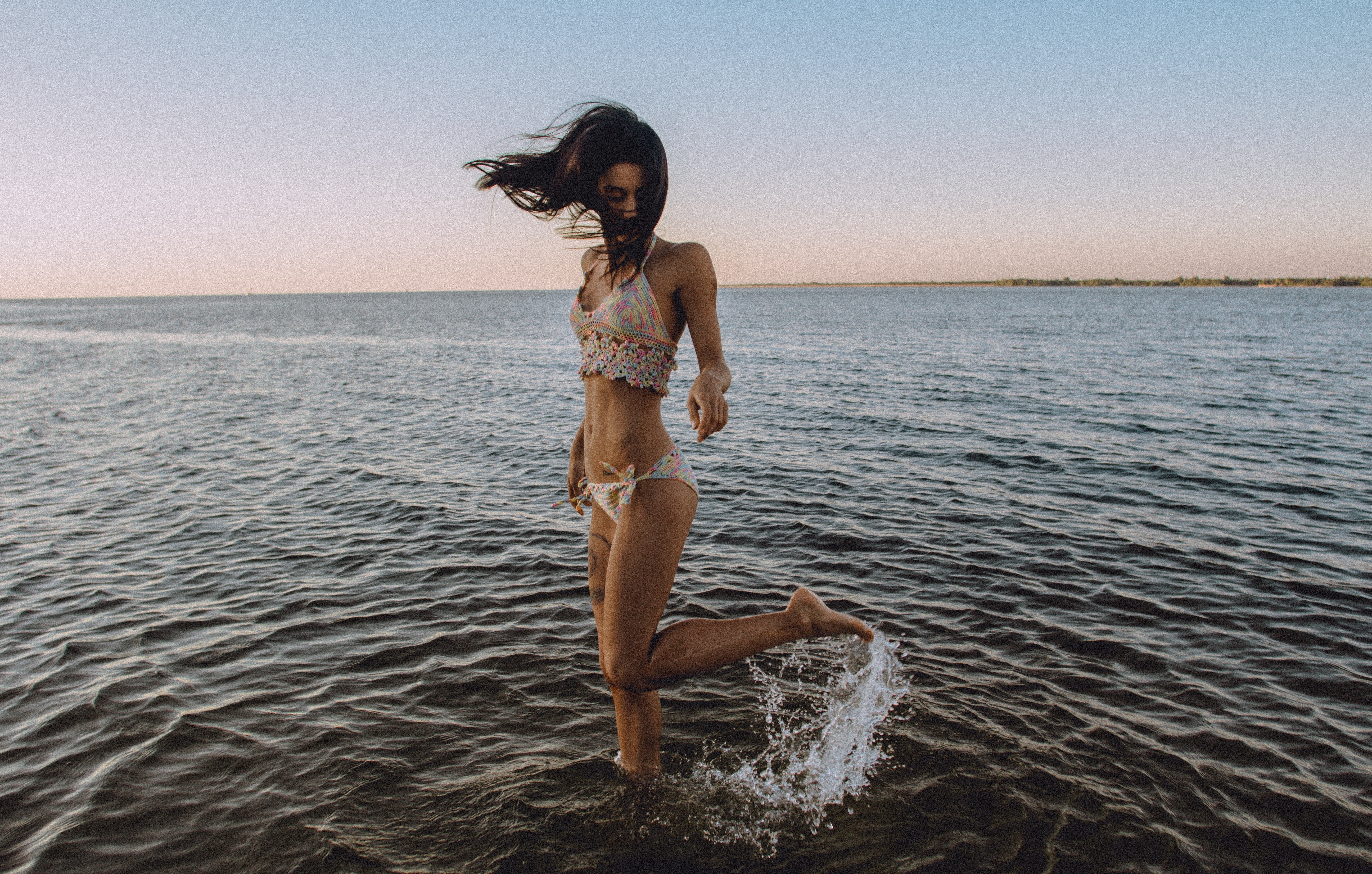 woman in white bikini on body of water posing for photo