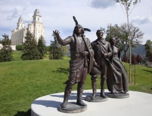 statue of native american near man and woman statue thumbnail