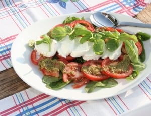 sliced tomato with green leaves dish thumbnail