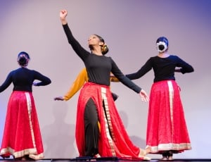 performers in black long long sleeve shirt and red skirt on stage thumbnail