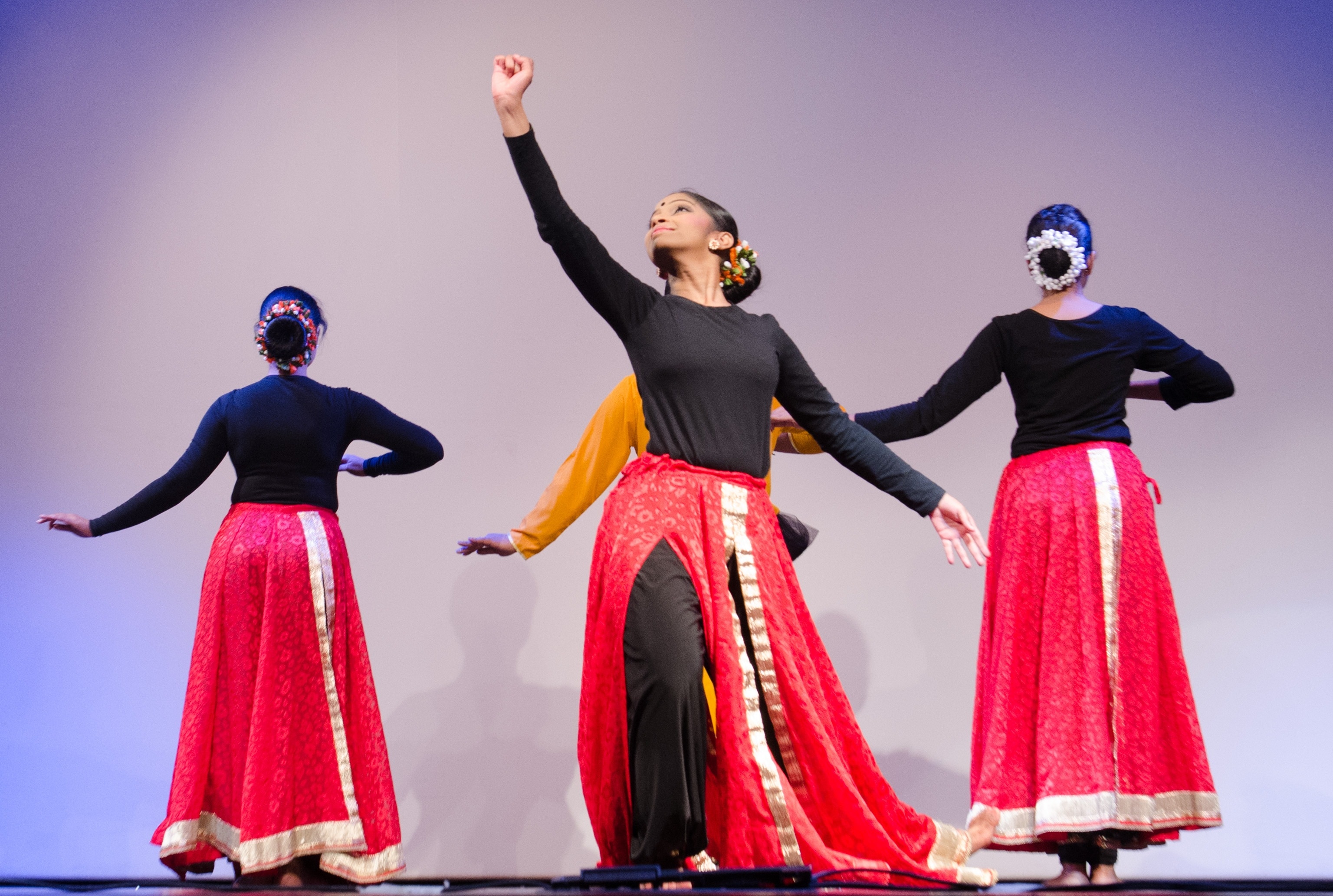 performers in black long long sleeve shirt and red skirt on stage