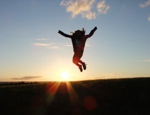 silhouette of human human jumping on the ground during sunset thumbnail