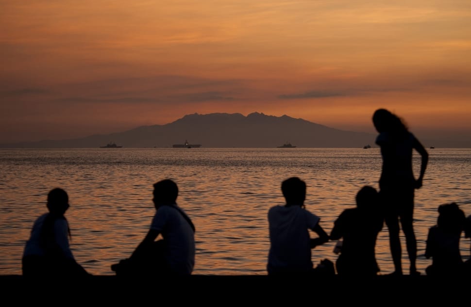 silhouette of people on sea shore during golden hour preview