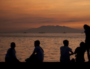 silhouette of people on sea shore during golden hour thumbnail