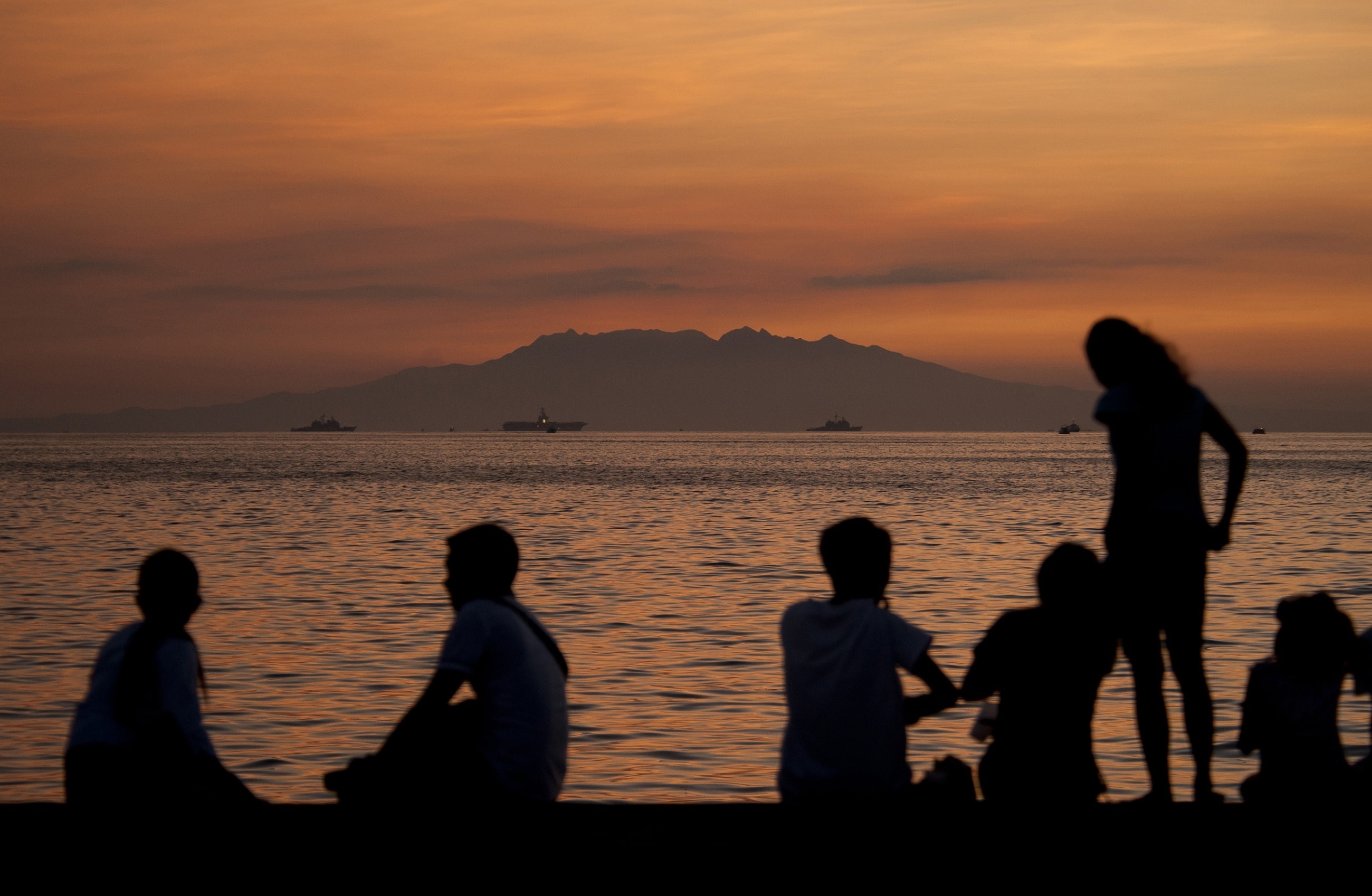 silhouette of people on sea shore during golden hour