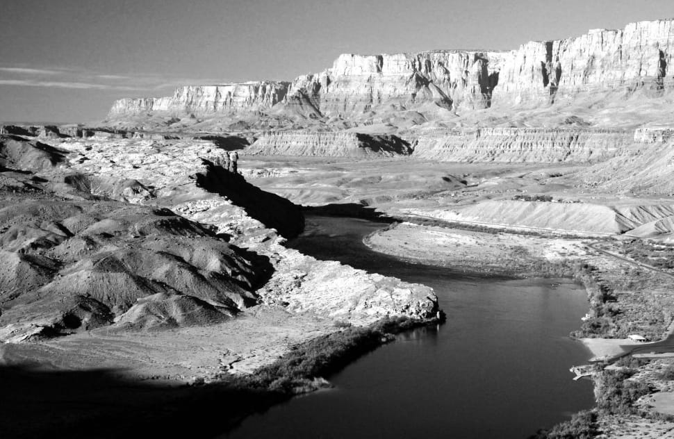 grayscale photography of rock formation with body of water preview