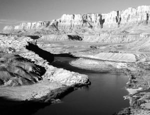 grayscale photography of rock formation with body of water thumbnail