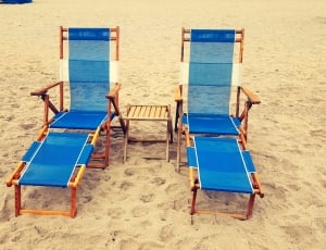 two brown wooden frame blue and white adirondack chair on sand thumbnail