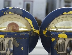 two blue and yellow time expired park meters thumbnail