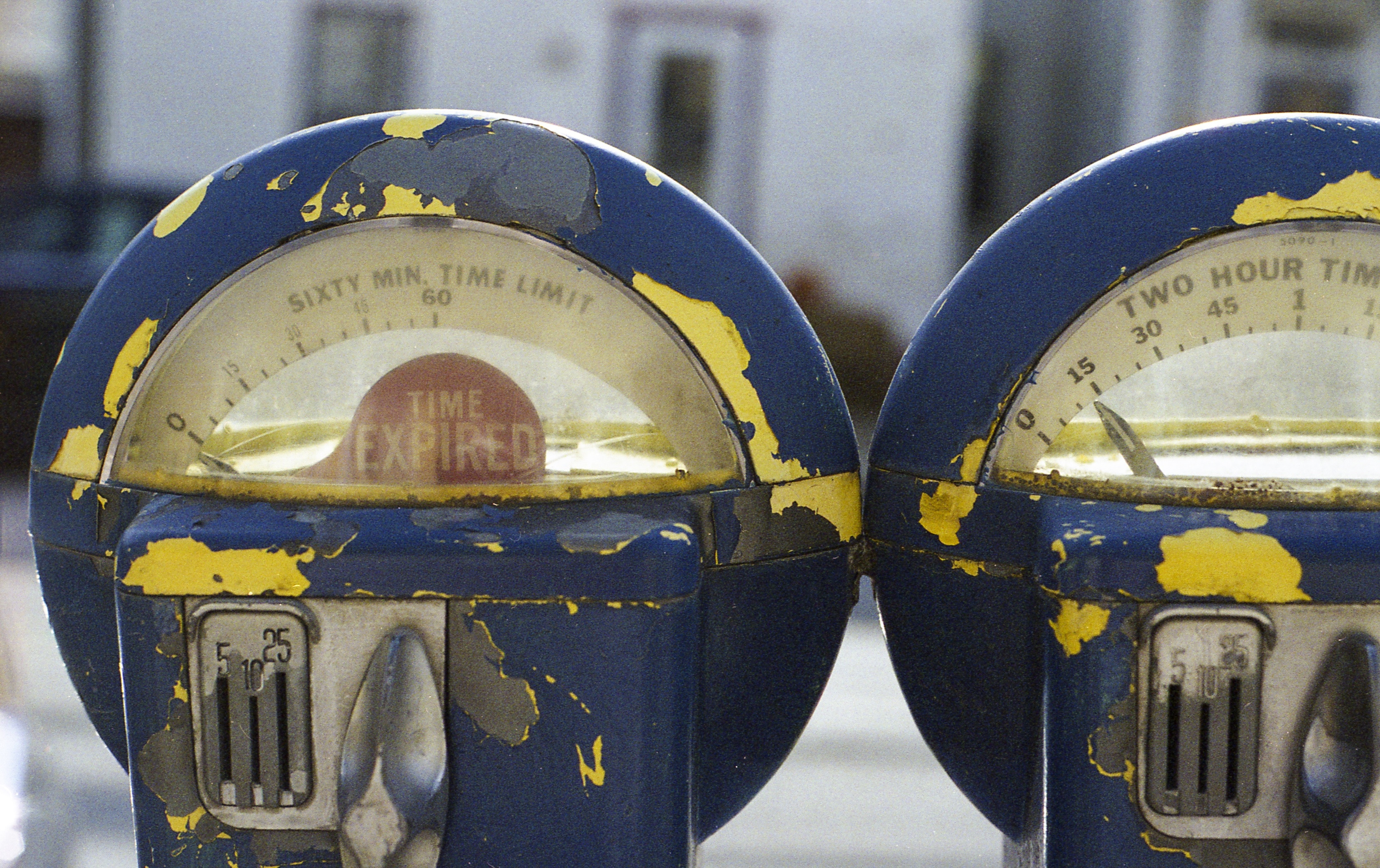 two blue and yellow time expired park meters