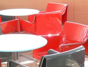 stainless steel base white table top and 4 red gray metal chairs thumbnail