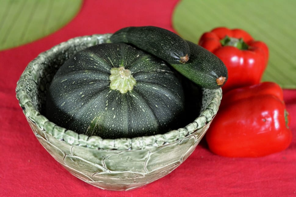 green and white round ceramic bowl with three vegetables on top preview