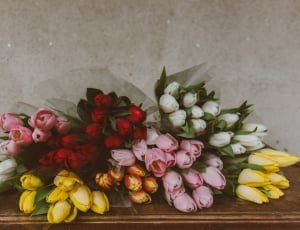 variety colored tulip bouquets on top of brown wooden tabkle thumbnail