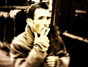 man smoking outside sepia photo thumbnail
