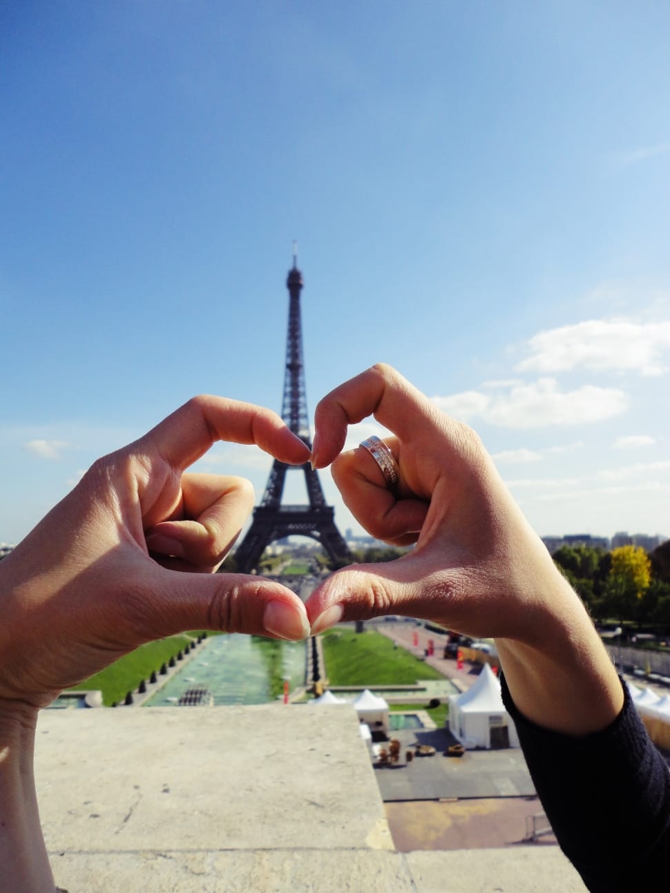 persons hand showing heart shaped in front of eiffel tower preview