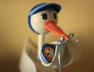 beige and blue bird carrying baby on his bill figurine thumbnail