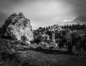 grayscale photo of rock formation near cliff thumbnail