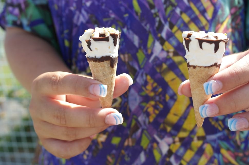 person holding two ice creams preview