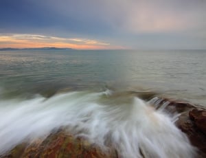 ocean waves hitting on rocks time lapse photo thumbnail