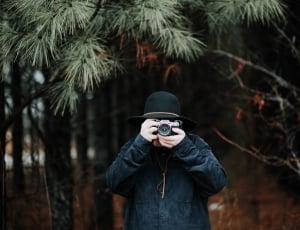 men's wearing black jacket taking picture using camera dslr during daytime thumbnail