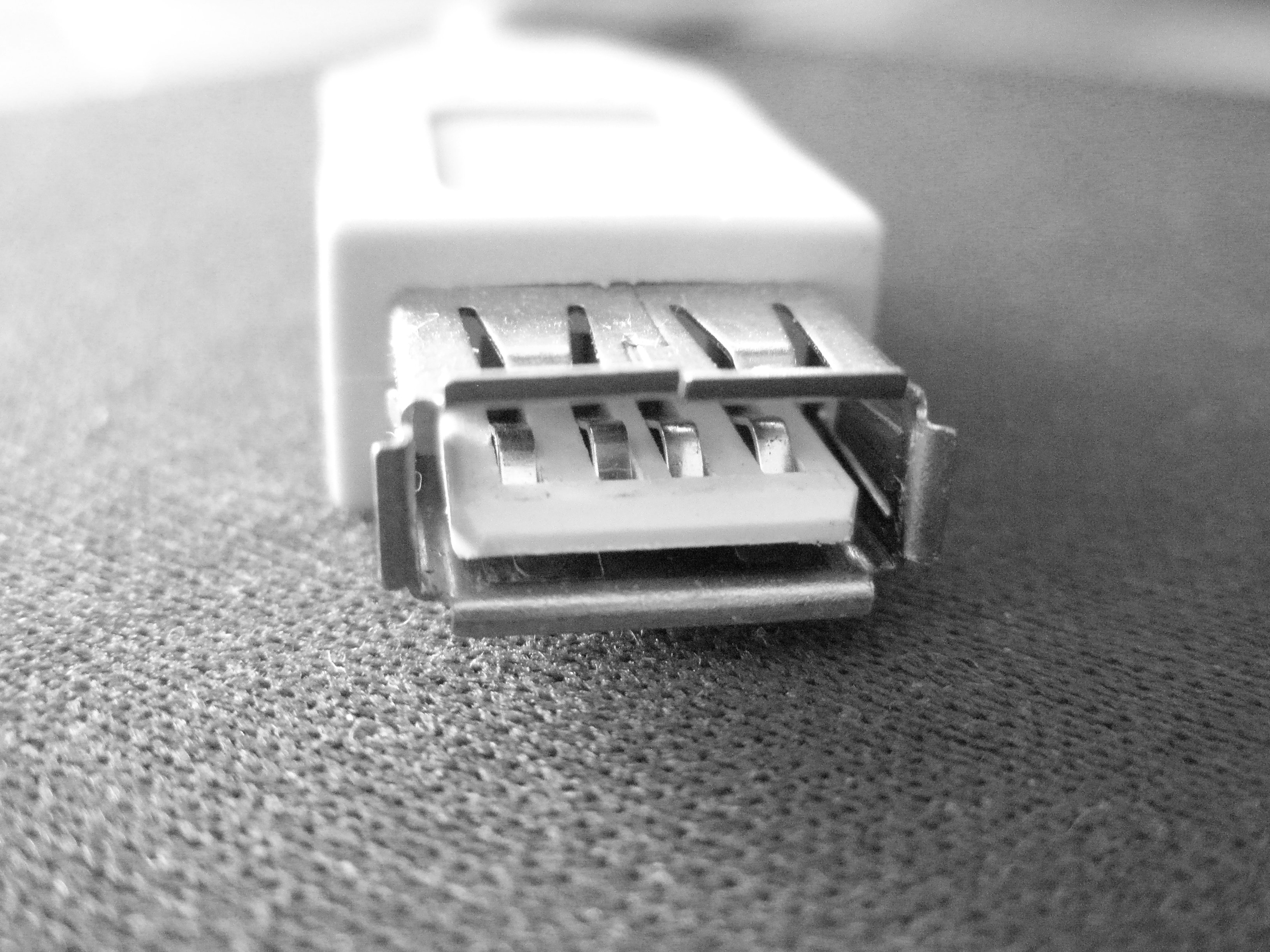 white USB cable placed on a gray textile