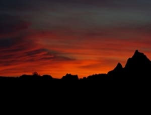 silhouette of hills under red sky during twilight thumbnail
