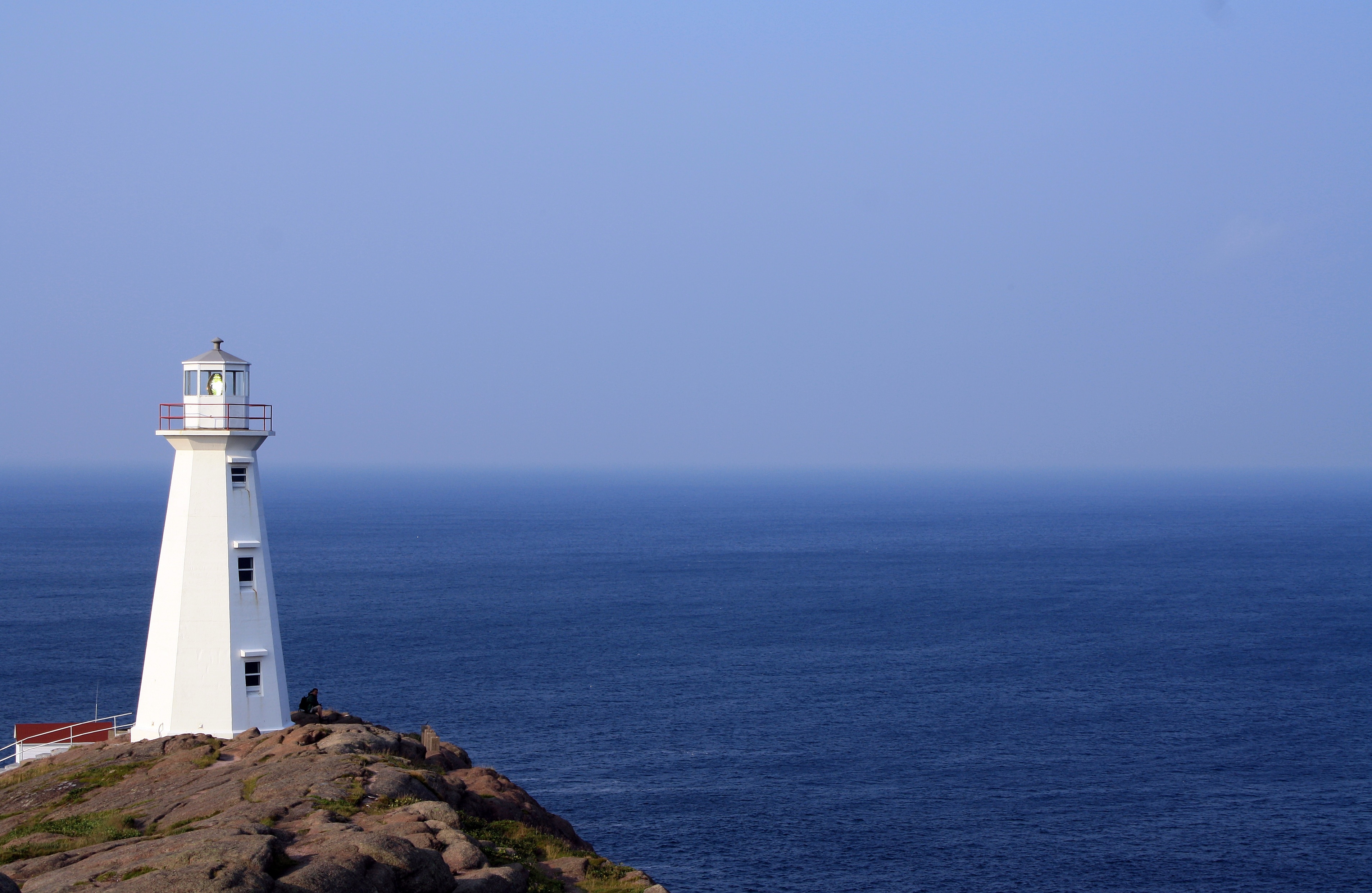 white lighthouse on top of cliff