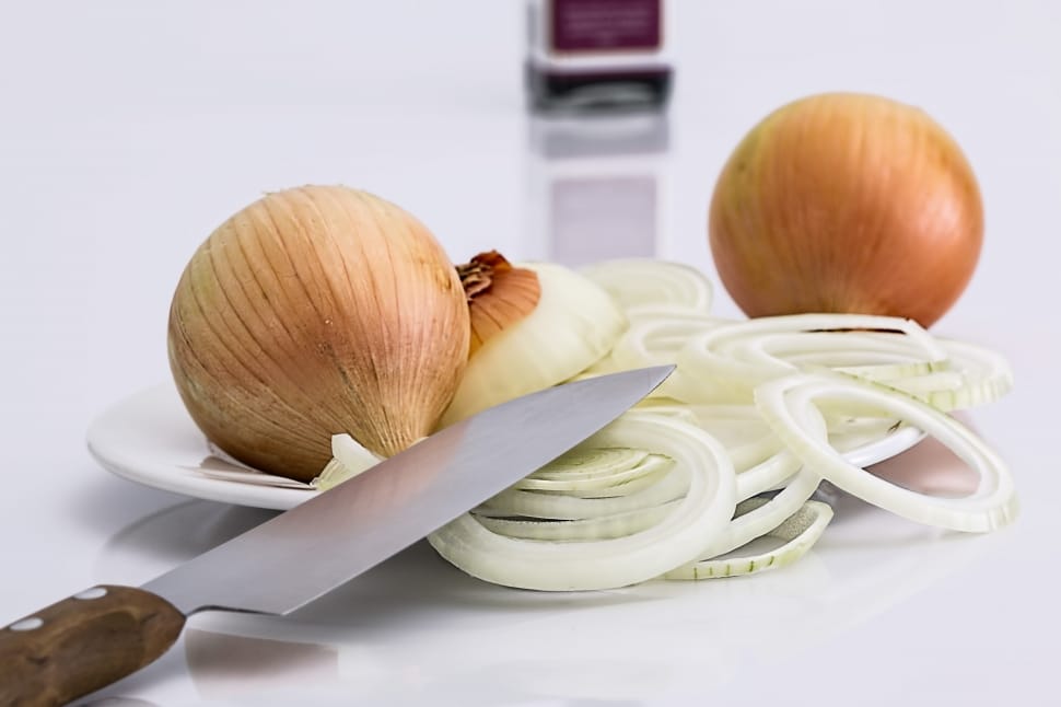 slice white onions and knife near white table preview