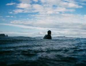 photo of a man in black wetsuit in body of water thumbnail