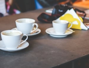 three pair of white ceramic cups and saucers on tabletop thumbnail