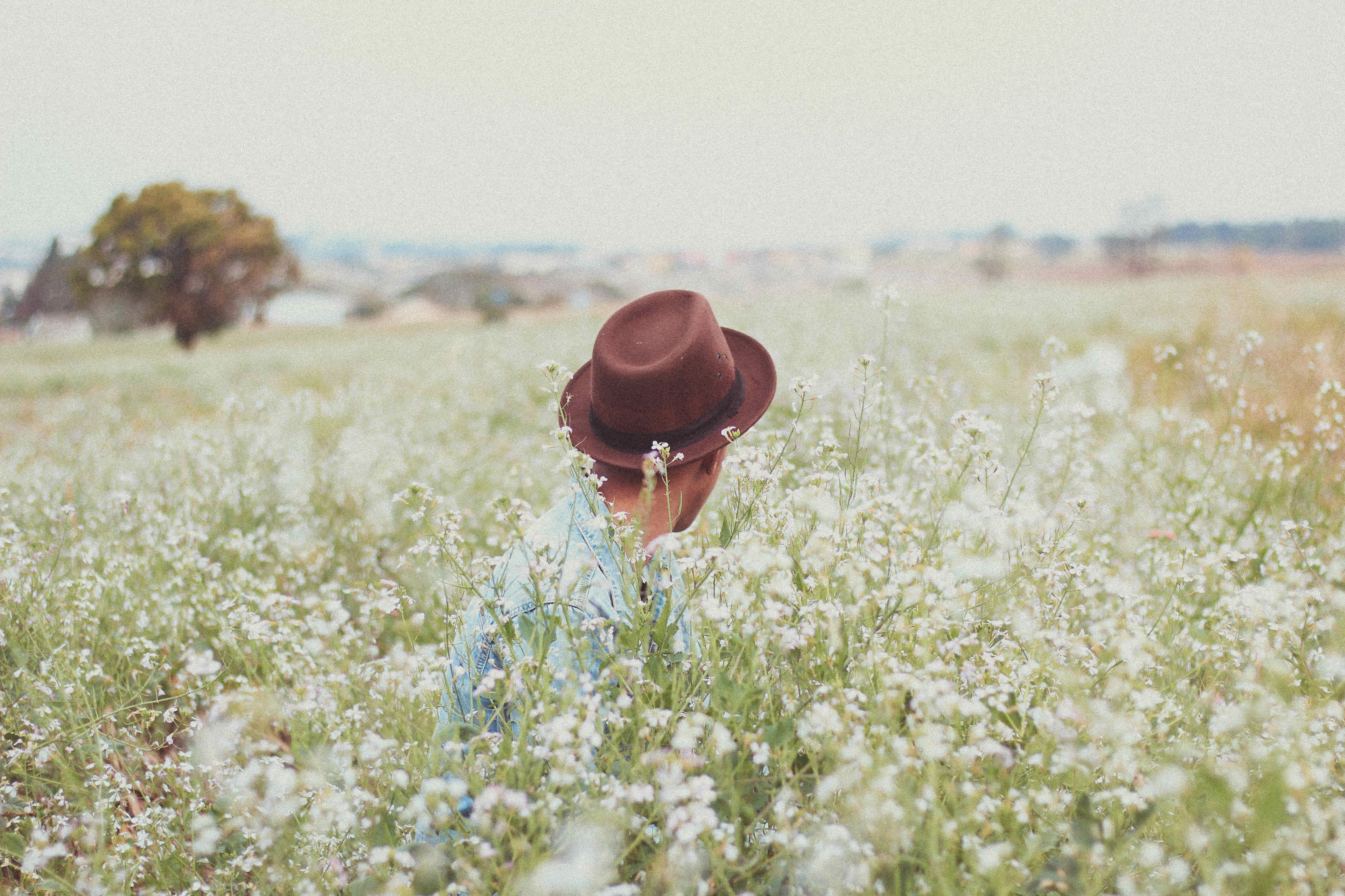 Выезд в поле. Человек в шляпе с полями. Фотосессия в поле летом. Мужчина в поле цветов. Человек в цветочном поле.