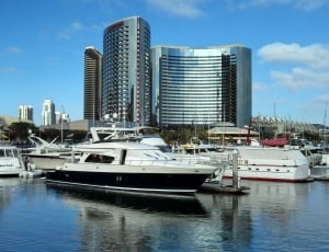 white and black boats on the boat ports with high rise building thumbnail